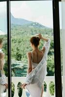 attractive young woman in lingerie on the balcony beautiful view from the window sunny day photo