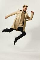 man in a beige coat circle movement light background photo