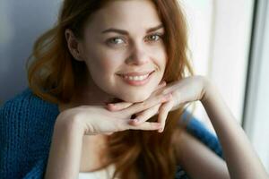 beautiful woman sitting on the windowsill with a blue plaid smile photo