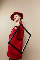 woman frame in hand in red hat and jacket isolated background photo