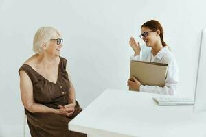 nurse in white coat talking to an elderly woman professional treatment photo