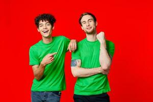 Two cheerful friends in green t-shirts are standing next to each other photo