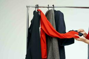 cheerful woman in a red jacket near the wardrobe retail light background photo