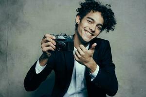 cute guy holding camera classic suit gesturing with hands smile joy model photo