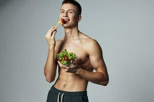 gracioso deportivo chico plato de ensalada sano comida recortado ver de rutina de ejercicio foto