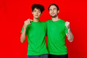 funny friends green t-shirts hugs emotions joy red background photo