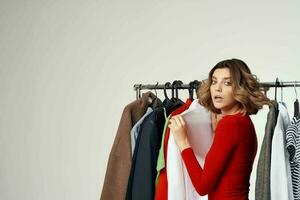 cheerful woman trying on clothes shop shopaholic light background photo