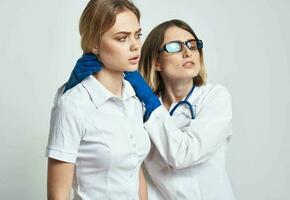 un enfermero en azul guantes examina un paciente en un blanco camiseta en un ligero antecedentes foto
