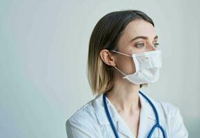 Woman doctor in a medical mask with a stethoscope around her neck photo