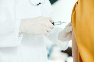 doctor giving injection to patient's shoulder close-up cropped view syringe epidemic covid photo