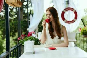 Portrait of young beautiful woman with red cup of coffee outdoors cafe Happy female relaxing photo