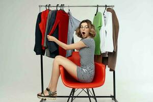 pretty woman with glasses next to clothes fashion fun retail emotions photo