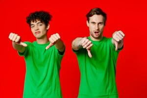 Happy Friends in Green T-shirts Show Thumbs Down Emotions photo