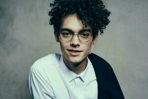 young guy with glasses curly hair jacket shirt portrait close-up photo