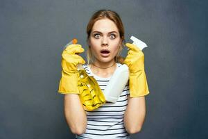 emocional limpieza dama vistiendo amarillo caucho guantes con detergente gris antecedentes foto