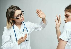 Nurse and patient gestures with hands light background stethoscope disease photo