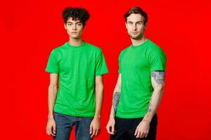 two friends green t-shirts fun red background communication photo