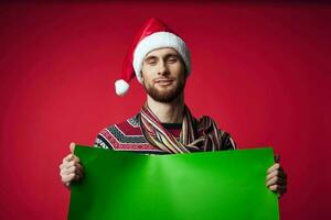 emotional man in a christmas hat with green mockup studio posing photo