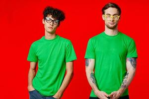 two friends are standing side by side in green T-shirts with glasses photo