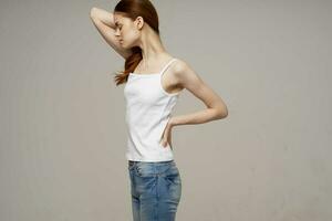 woman in white t-shirt chiropractic rheumatism health problems light background photo