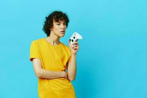 man plays with joystick in yellow t-shirts isolated backgrounds photo