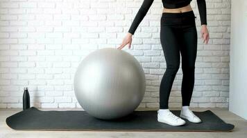 fitness, sport e stile di vita sano. giovane donna che lavora a casa con una palla di stabilità o una palla fitness. allenamento a casa video