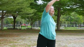 Aging mature woman do fitness outdoors in park at morning, fitness concept Taking care of the physical health of the elderly. Concept of health care of seniors, cardio workout in park at morning video