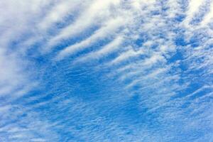 Wavy white clouds spread in the blue sky. Sky background. photo