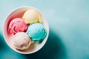 A bowl of colorful ice creams on a blue background, ice cream balls in cup, top view. photo