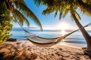 Hammock on the beach between palm trees against the backdrop of a beautiful sunset. . photo