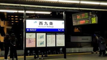 Osaka, Japan in April 2019. Signboard of Nishikujo Station with kanji and katakana writing. photo