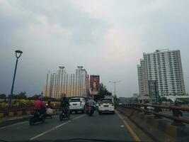 Bekasi, Indonesia in March 2019. Congestion conditions that occur on one side of the flyover in East Bekasi. You can see two apartment buildings, Kemang View on the left side photo