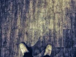 A pair of white shoes on a floor with a wooden texture. photo