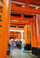 kioto, Japón en abril 2019. turistas tomando imágenes y caminando en el fushimi inari zona de Kioto. foto