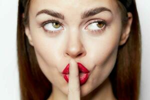 portrait of woman close-up finger near red lips look towards photo