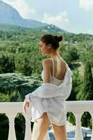 woman in lingerie on the balcony beautiful view from the window sunny day photo