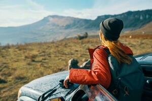 viajero en un sombrero con un mochila cerca el coche puerta en naturaleza foto