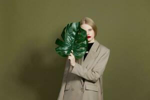 blonde woman green palm leaf coat bright makeup studio model unaltered photo