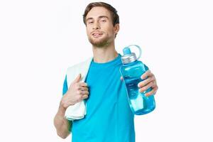 deportivo hombre en azul camiseta agua botella toallas rutina de ejercicio foto