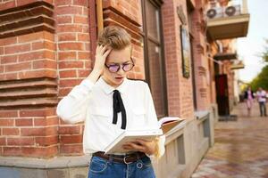short haired woman with a book in his hands outdoors reading Lifestyle photo