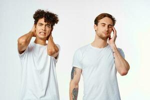 two friends in white t-shirts hold their heads emotions photo