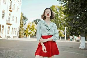 cheerful woman in red skirt in the square outdoors posing photo