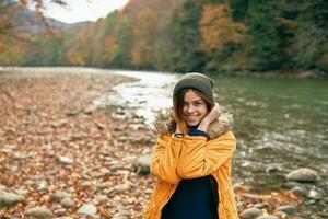 woman in yellow jacket on nature travel river autumn photo