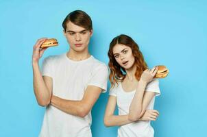 young couple with hamburgers in their hands fast food snack junk food photo