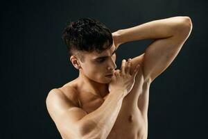 sporty man with pumped up muscular body holds his hand behind his head posing photo