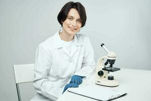 female laboratory assistant in white coat research science biology photo