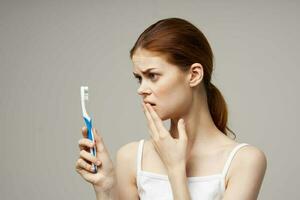 cheerful woman with a toothbrush in hand morning hygiene isolated background photo