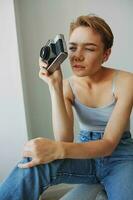 Woman photographer shooting in studio on old film camera at home on couch portrait, white background, free copy space, freelance photographer photo