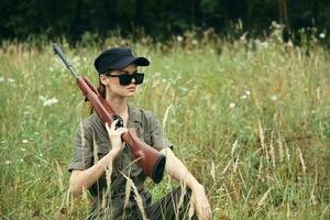 Woman on nature Sunglasses with arms on the shoulder sheltering in the grass weapons photo