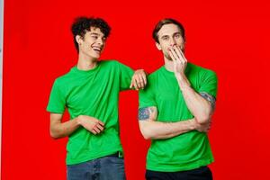 dos alegre amigos en verde camisetas son en pie siguiente a cada otro foto